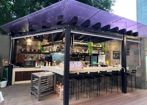 a bar on a deck with a purple awning at Grand Tower Del Valle in Mexico City