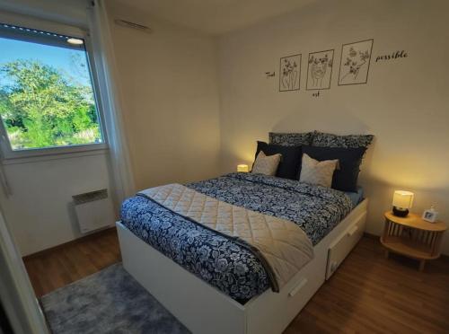 une chambre avec un grand lit et une fenêtre dans l'établissement Charmant Appartement Cozy, à Saint-Jory