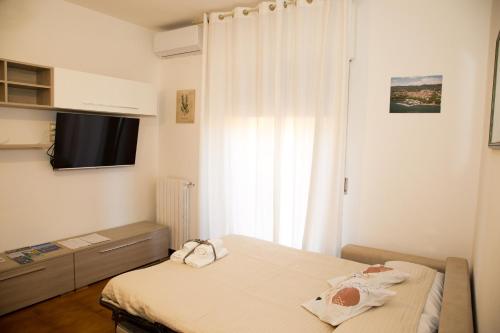 a small bedroom with a bed and a television at Le Floreali - Casa Rosmarino in Bolsena