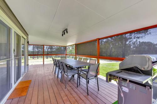 porche cubierto con mesa, sillas y parrilla en Magpie Three- Two for Joy Estate. 2.5 Bathrooms sleeping 6, en Greta