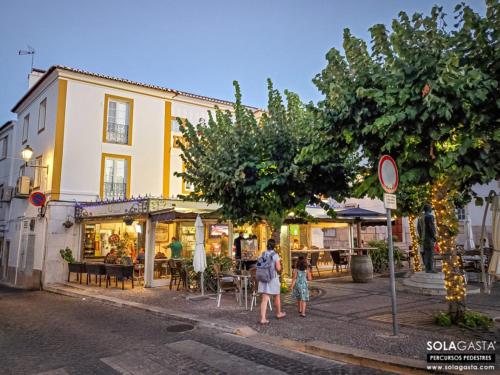 a woman and a child walking down a street at A Casa da Praça in Vila Viçosa