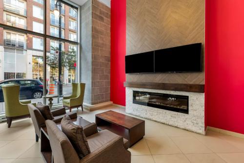a living room with a fireplace and a flat screen tv at Best Western Plus Hotel Montreal in Montréal