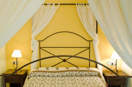 a bedroom with a canopy bed with two night stands at Hostal Sixto in Rota
