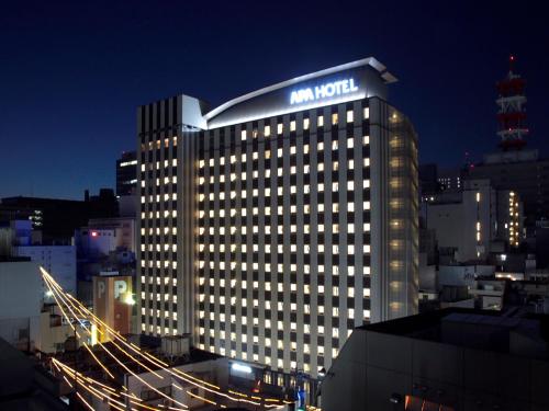 名古屋市にあるアパホテル 名古屋栄の夜間の看板のある建物