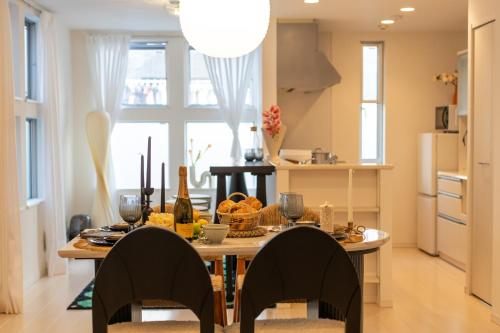 a kitchen with a table with food and wine glasses at Hotel Beswe in Tokyo