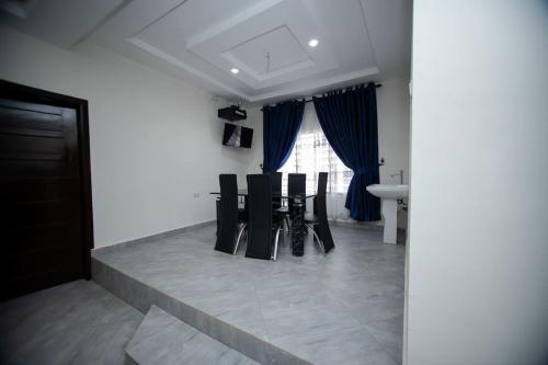 a room with chairs and a table and a window at Luxury House in Trede Kumasi in Kumasi
