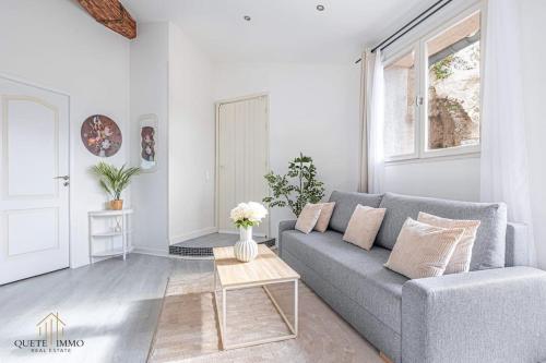 un salon avec un canapé gris et une table dans l'établissement Vue Panoramique et confort d'exception Proche Monaco, à Peille