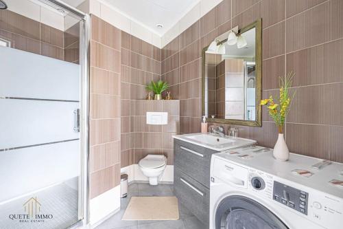 une salle de bain avec une machine à laver et un lavabo dans l'établissement Vue Panoramique et confort d'exception Proche Monaco, à Peille