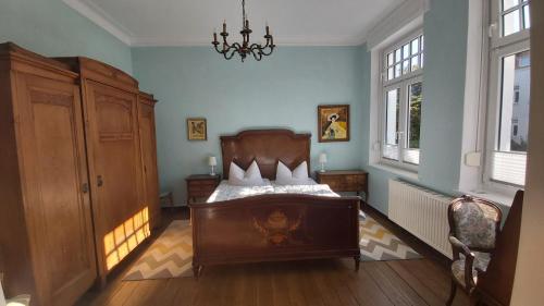 ein Schlafzimmer mit einem Bett und einem Kronleuchter in der Unterkunft Villa Romantica Lenzen in Körbitz