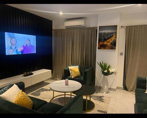 a living room with a couch and a tv at The Signature Hotel Apartment Accra Ghana in Accra