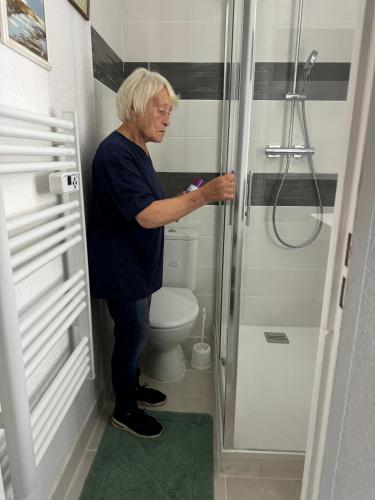 un homme debout dans une salle de bains avec toilettes dans l'établissement cottage duplex Villers sur mer 150 m de la plage, à Villers-sur-Mer