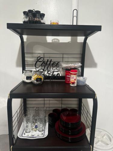 a black shelf with plates and dishes on it at Luxury Guest House - Cheap JFK Pick up & Drop Off Available in Jamaica