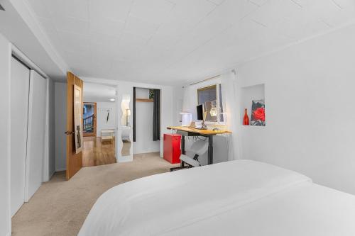a white bedroom with a bed and a desk at Green Lake Zen Garden Basement in Seattle