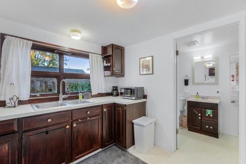 a kitchen with wooden cabinets and a sink and a window at Green Lake Zen Garden Basement in Seattle