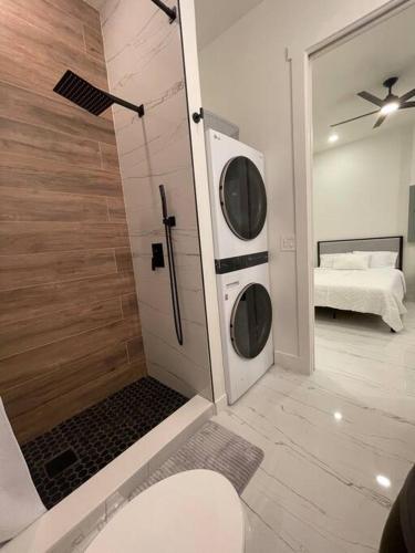 a bathroom with a shower and a washer and dryer at Casa Blanca Studio with Washer Dryer in Lehigh Acres