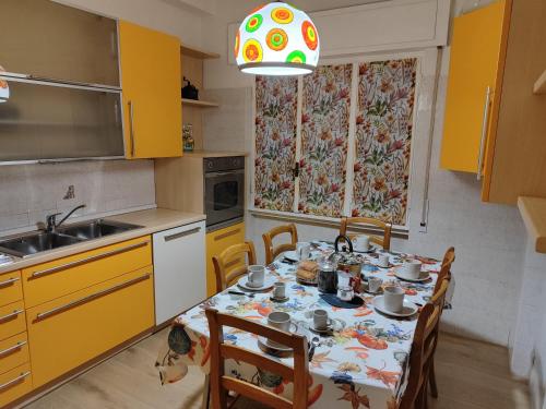a kitchen with a dining room table with yellow cabinets at A&B Vatican Domus in Rome