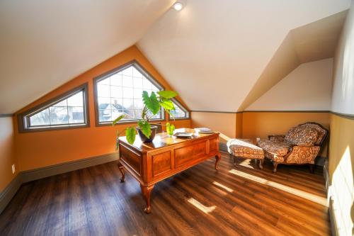 an attic room with a piano and a chair at Niagara Grandview Boutique Hotel in Niagara Falls