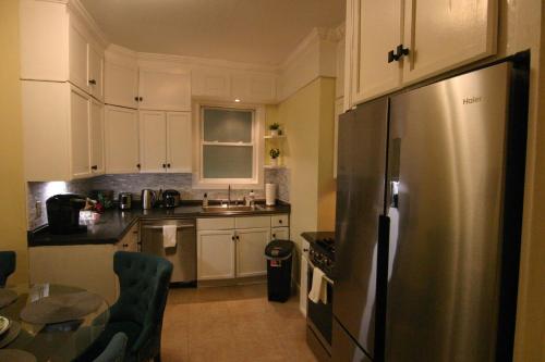 a kitchen with white cabinets and a stainless steel refrigerator at Spacious 4BR Near Subway, Sleeps 8per Easy Access to Downtown Boston in Boston
