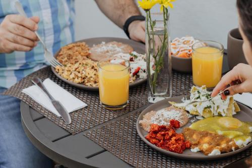 a table topped with plates of food and orange juice at Casa Raco - Parras de la Fuente in Parras de la Fuente