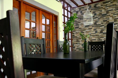 a dining room with a black table and chairs at Hotel Baltsol in Managua