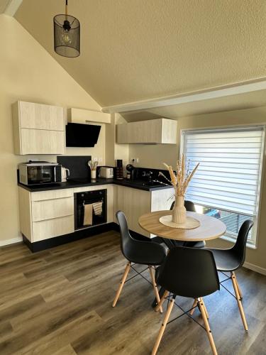 une cuisine avec une table et des chaises et une cuisine avec un comptoir dans l'établissement Séjour idéal, à Navenne