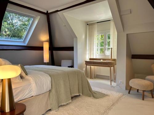 une chambre avec un lit, une table et une fenêtre dans l'établissement Country house in foresr of Rambouillet, à Auffargis