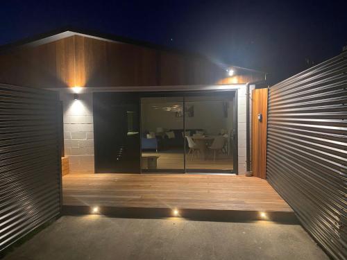 a house with a wooden porch at night with lights at The Cedar Inn in Blenheim