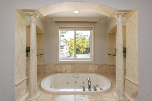 una bañera en un baño con ventana en Miami House - Heated Pool - Family Vacation, en Miami