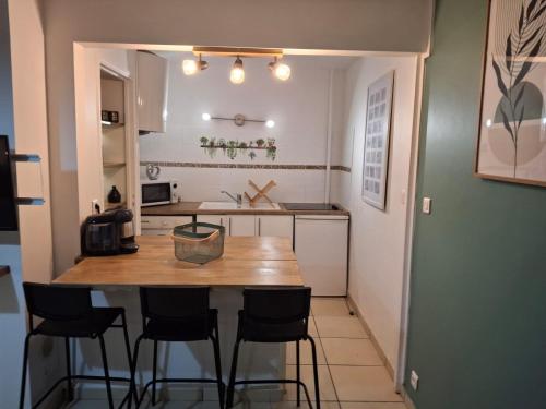 une petite cuisine avec une table et des chaises en bois dans l'établissement endroit doux au centre ville, à Toulouse