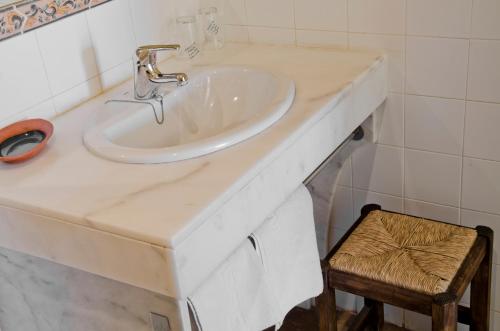a white sink in a bathroom with a stool at Hostal Sixto in Rota