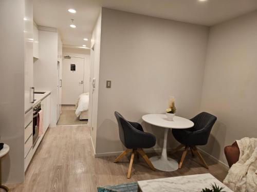 a dining room with a table and two chairs at Urban Haven - Spa, Pool and Patio in Auckland
