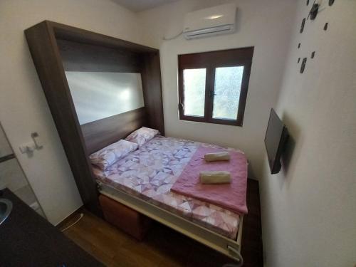 a small bedroom with a bed with a mirror at Apartment Marija in Risan