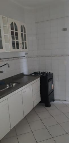 a kitchen with a sink and a stove in it at Apartamento a 50 metros da praia in Caraguatatuba