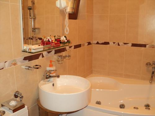a bathroom with a sink and a bath tub at Casa Anca Boutique Hotel in Braşov