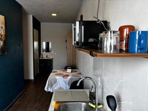 a small kitchen with a sink and a microwave at Hotel Hostal Dulce Hogar in Tuxpan