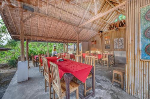 a dining room with a red table and chairs at NG Sweet Home in Nusa Penida