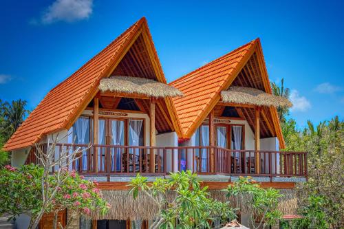 a house with an orange roof and a balcony at NG Sweet Home in Nusa Penida