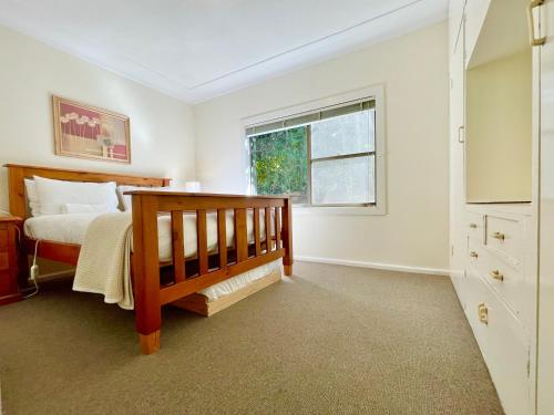 a bedroom with a bed and a window at Raspberry Terrace of Leura in Leura