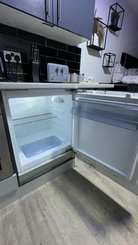 a kitchen with an empty refrigerator in a kitchen at Studio apartment in bolton town in Bolton