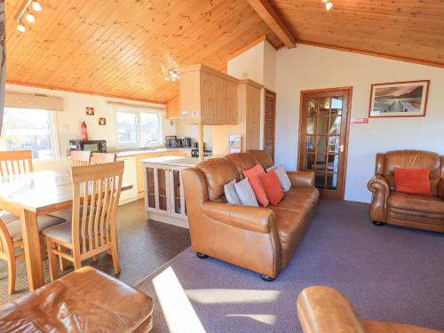 a living room with a leather couch and a table at Kellet Lodge Lakeside 26 in Carnforth