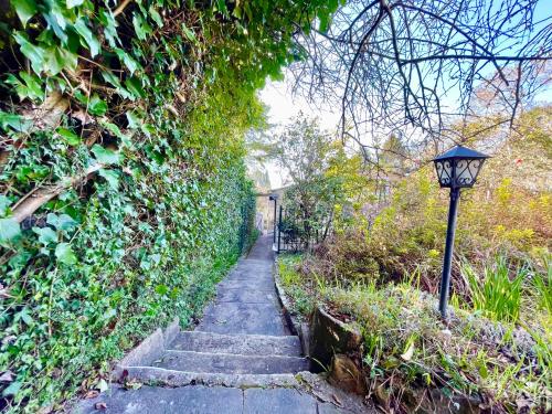 a stone path with a street light next to a hedge at Raspberry Terrace of Leura in Leura