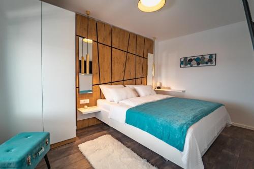 a bedroom with a large bed and a blue stool at Seaside luxury villa with a swimming pool Razanj, Rogoznica - 23572 in Rogoznica