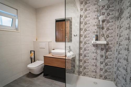 a bathroom with a toilet and a sink and a shower at Seaside luxury villa with a swimming pool Razanj, Rogoznica - 23572 in Rogoznica