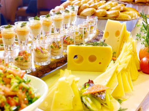 a buffet of food with cheese sandwiches and dips at Olive Tree Hotel in Jerusalem