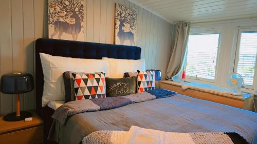 a bedroom with a large bed with a blue headboard at Room In Handsome Haven House in Gjøvik