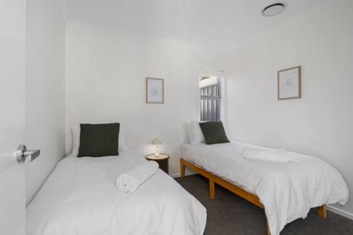 two beds in a room with white walls at Eve House 1 Thurgoona in Thurgoona
