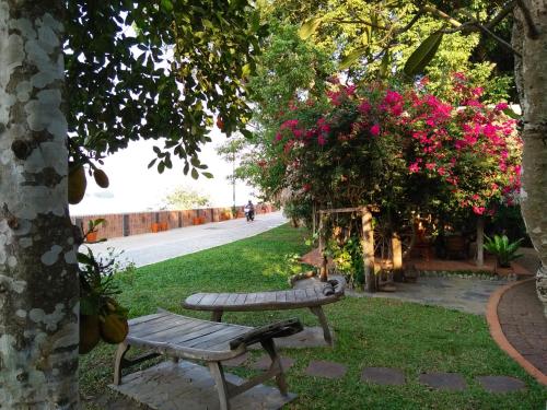 a park with a bench and pink flowers at Mut Mee Garden Guest House in Nong Khai
