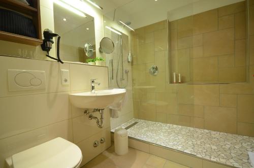 a bathroom with a toilet and a sink and a shower at Hotel Kleins Wiese in Schmallenberg