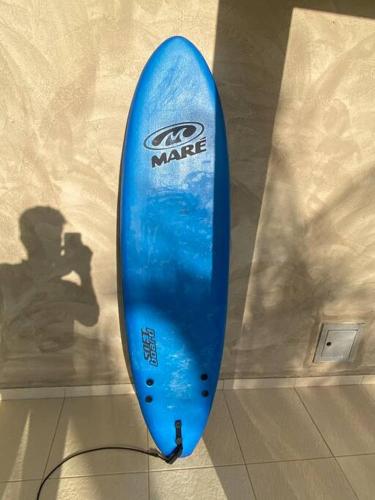 a blue surfboard is leaning against a wall at Praia da Espera - Paraíso em Itacimirim - Quinta das Lagoas Reserva in Monte Gordo
