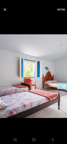 a bedroom with two beds and a window at Estância Morro Do Frota in Pirenópolis